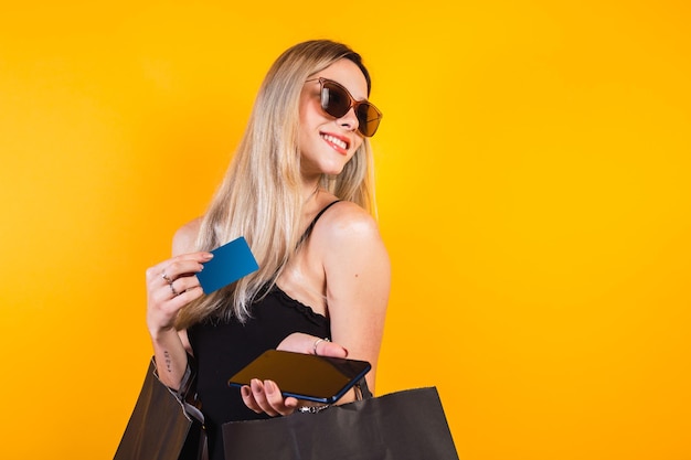 Young woman holding shopping bags and talking on the phone.