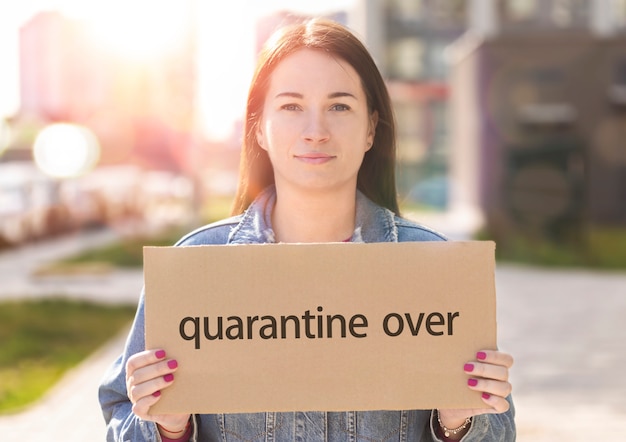 Young woman holding sign with the inscription quarantine over