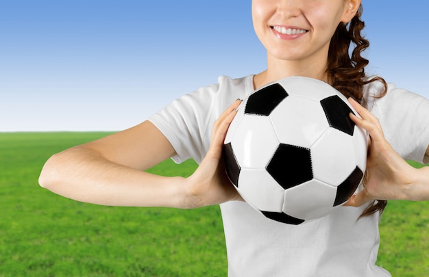 Young woman holding soccer ball on her hand