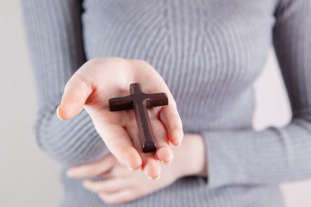 Young woman holding a wooden cross