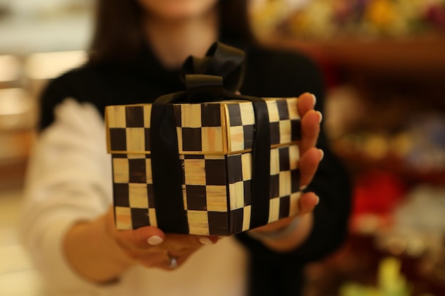 Young woman holds a gift box with her hands