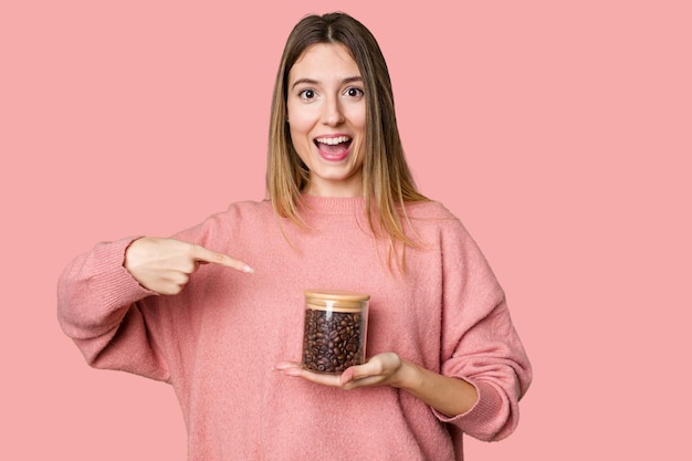 A young woman holds a jar filled with aromatic coffee beans ready for a delicious morning brew