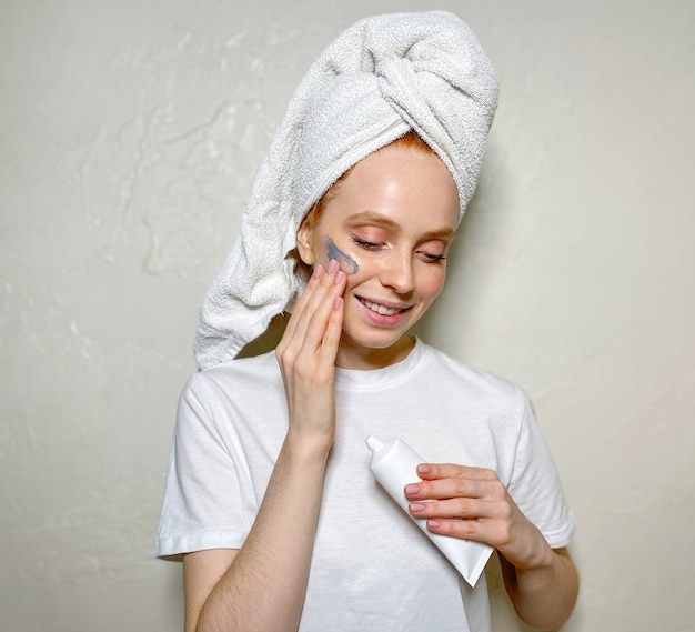 Young woman at home with a towel on her head