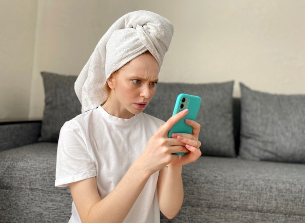 Young woman at home with a towel on her head