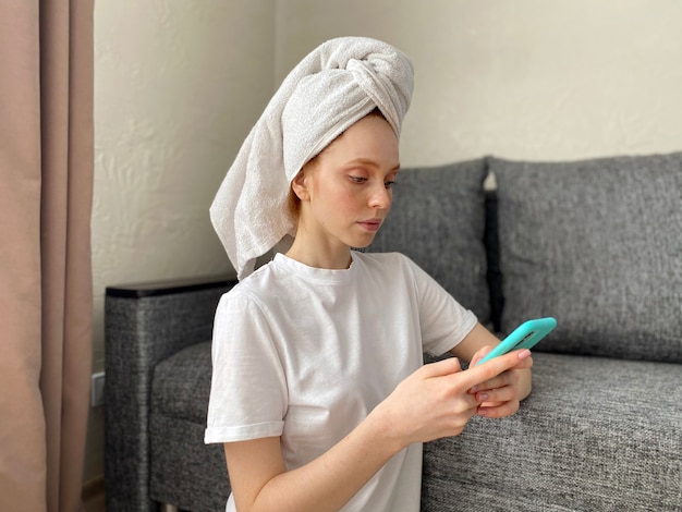 Young woman at home with a towel on her head