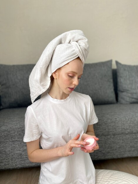 Young woman at home with a towel on her head