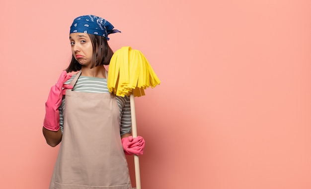 Photo young woman housekeeper looking arrogant, successful, positive and proud, pointing to self