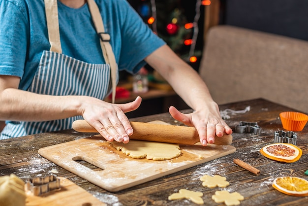 Young woman housewife makes dough for cooking festive ginger cookies