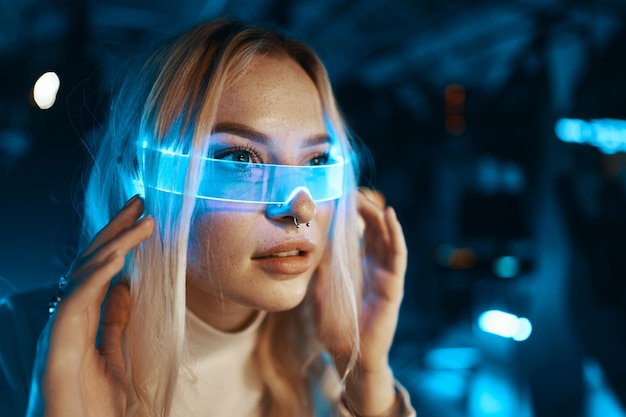 The young woman is all dressed in white and wearing neon glasses Neon style Portrait of a blonde in fashionable glasses