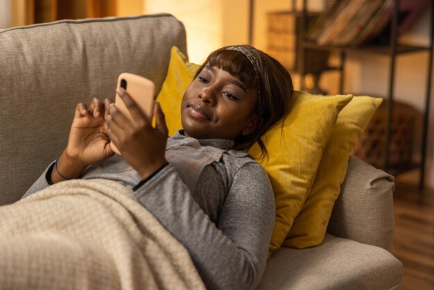 A young woman is browsing popular websites on her smartphone fixated on the opportunity to shop