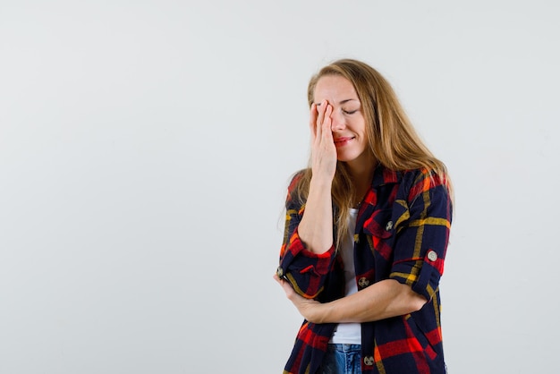 The young woman is covering her left eye with hand  on white background