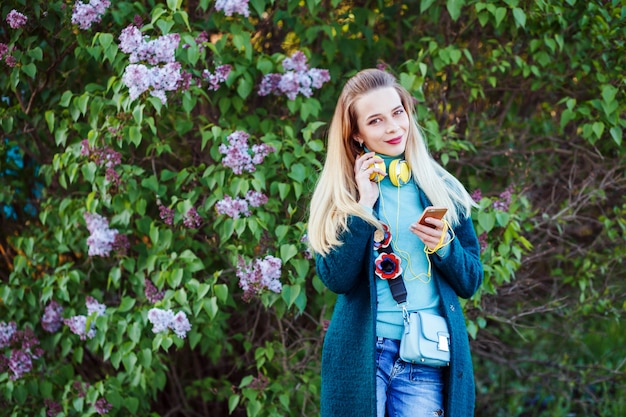 Young woman is looking at her phone choosing music to listen