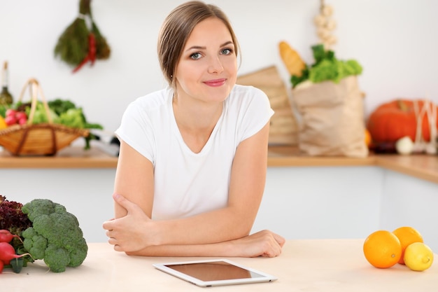 Young woman is making online shopping by tablet computer and credit card Housewife found new recipe for cooking in a kitchen