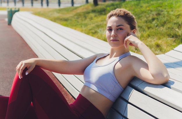 A young woman is preparing for outdoor sports on the modern promenade near her apartment complex