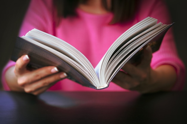 Young woman is reading a book at home.