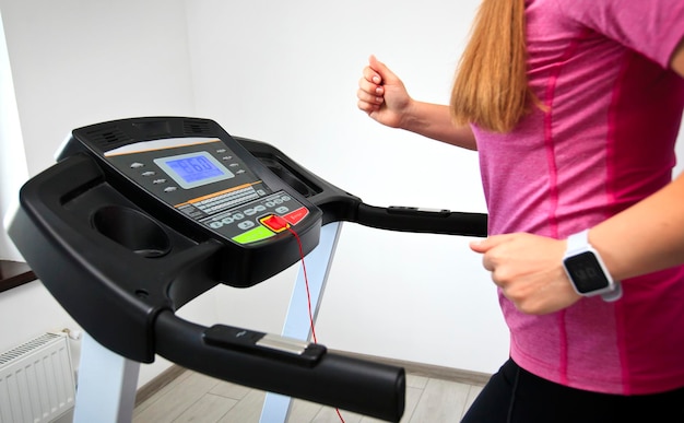 The young woman is running on her treadmill in home