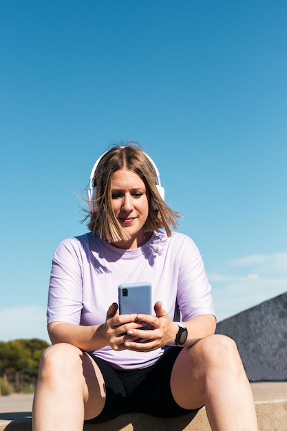 Young woman is sitting and listening to music with headphones