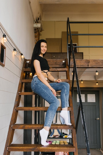 Photo young woman is sitting on the stairs in a house on the second floor