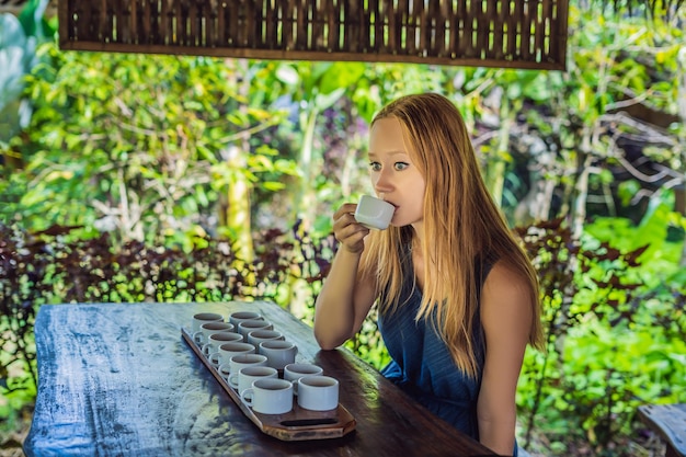 A young woman is tasting different kinds of coffee and tea, including coffee Luwak.