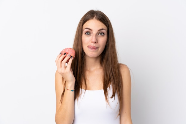 Young woman over isolated white wall holding a donut