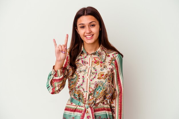 Young woman isolated on white wall showing a horns gesture as a revolution concept