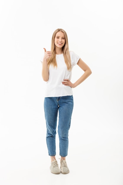 young woman in jeans looking at the camera giving a thumbs up of success 