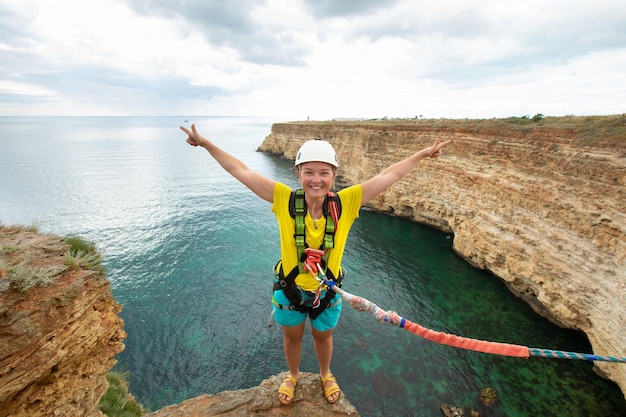 Young woman jump from the cliff with a rope Ropejumping