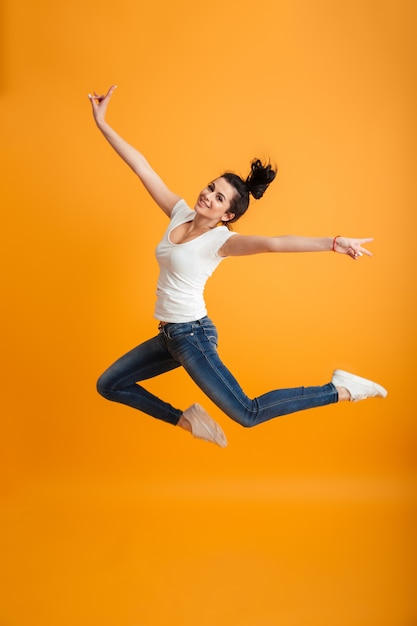 Young woman jumping make peace gesture.