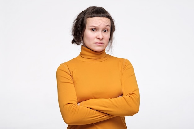 Young woman  keeping arms folded, having distrustful suspicious look