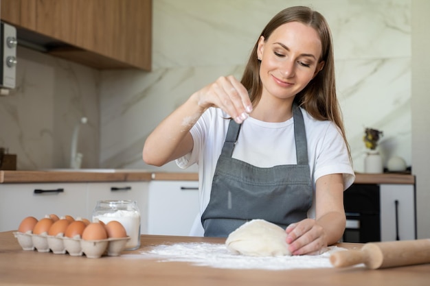 Young woman in the kitchen A beautiful woman kneads the dough with her hands