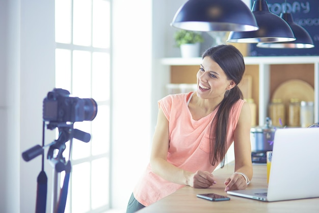 Young woman in kitchen with laptop computer looking recipes smiling food blogger concept