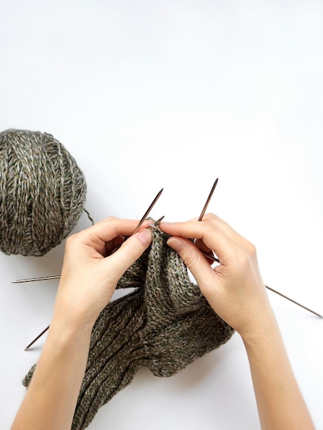 Young woman knitting wool sock top view