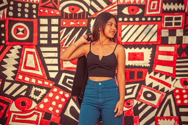 Young woman leaning on a wall with graffiti