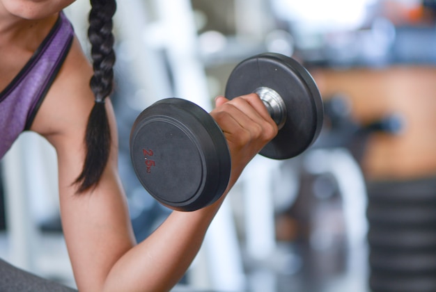 Young  woman lift up dumbbell, Gym Fitness concept.