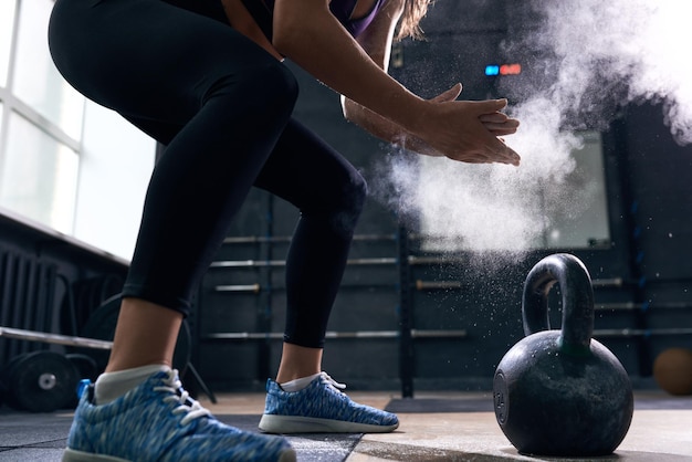 Photo young woman lifting kettlebells in crossfit gym