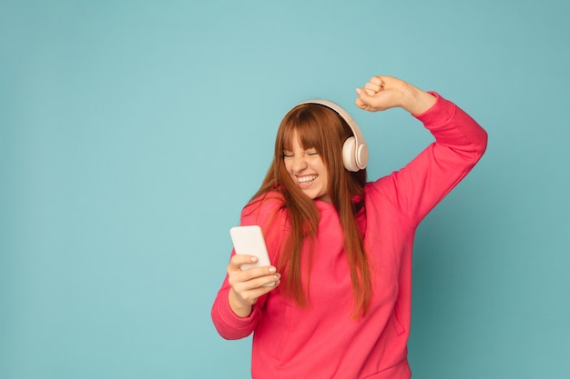 Young woman listening to music holding smartphone