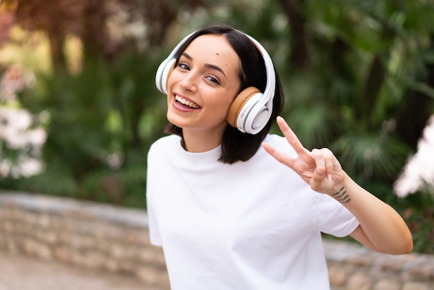 Young woman listening music at outdoors