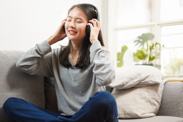 Young woman listening to music on the sofa