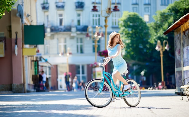 Young woman looking around while cycling in the city center