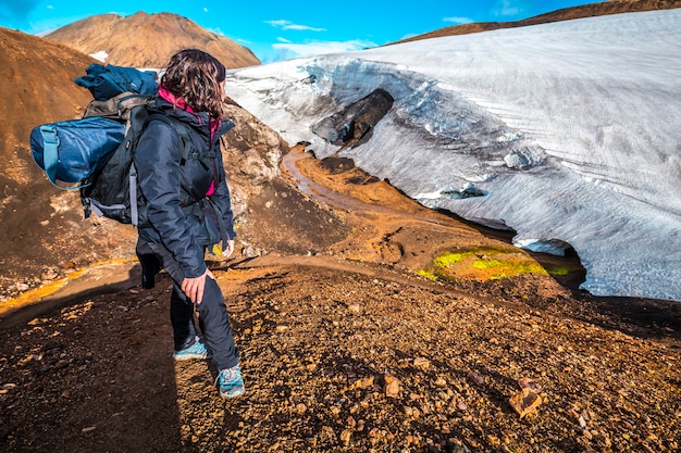 A young woman looking at a glacier at the highest point of the 4-day trek from Landmannalaugar. Iceland