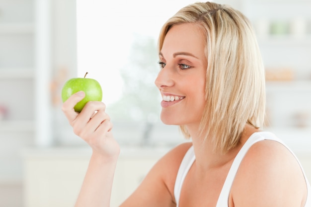 Young woman looking at green a apple