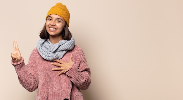 Young woman looking happy putting her hand on her chest