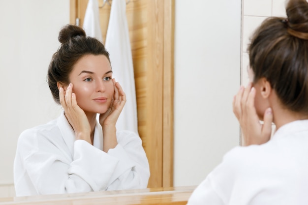 Young woman looking into the mirror