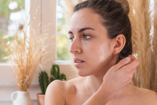 Young woman looking at the side halfnaked out of the shower with bright face