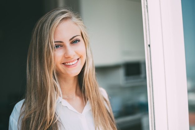 Young woman looking through the window