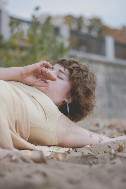 Photo young woman lying while dancing at beach