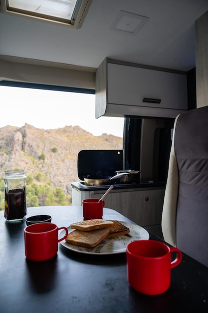 Young woman making breakfast in a motor home.