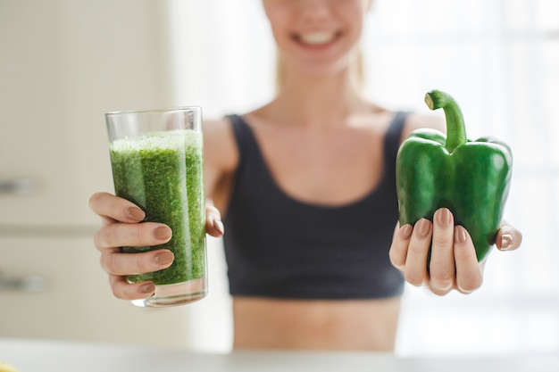 Young woman making detox smoothie at home