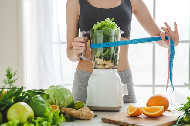 Young woman making detox smoothie at home