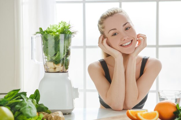 Young woman making detox smoothie at home